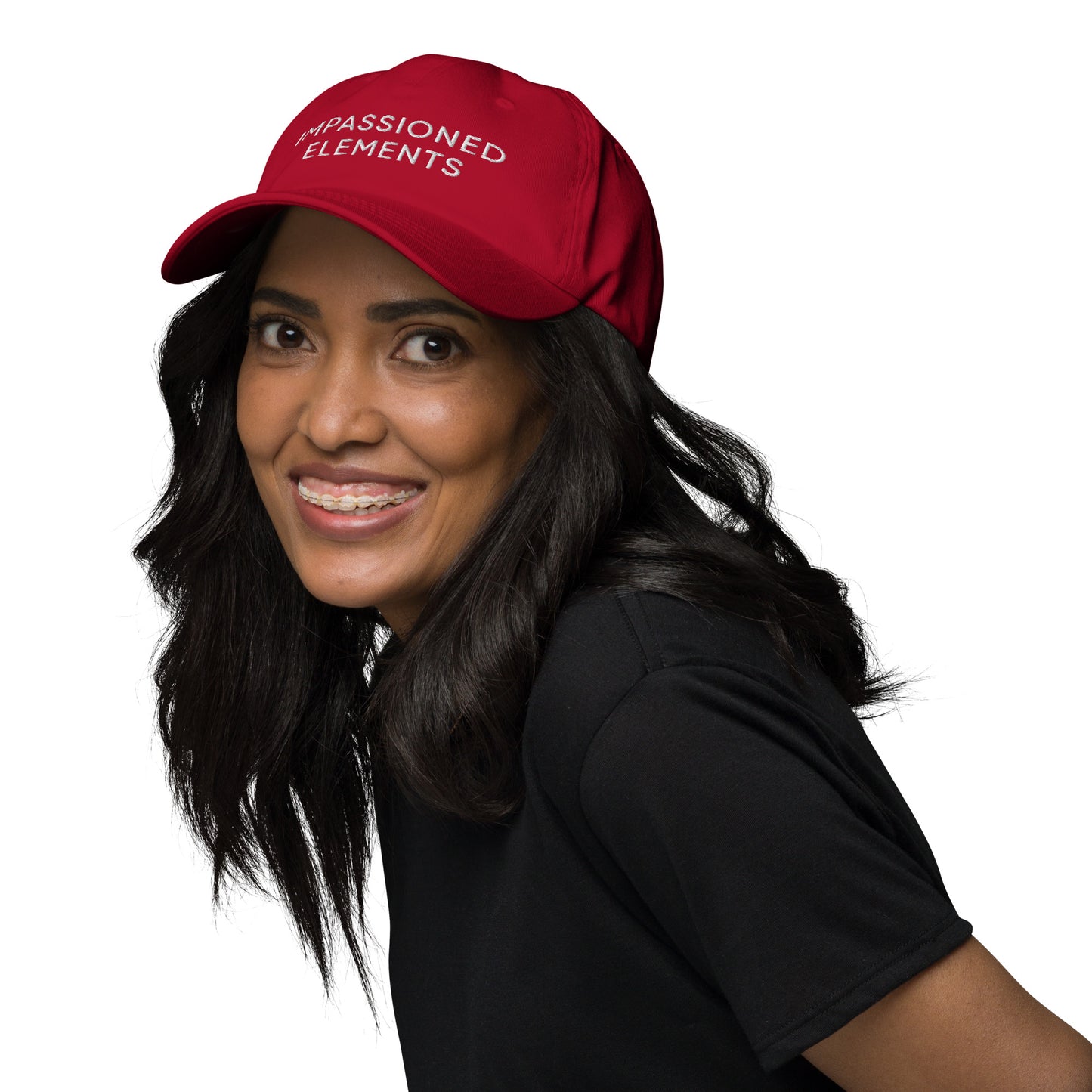 A woman smiling wearing our cranberry Impassioned Elements unstructured cap