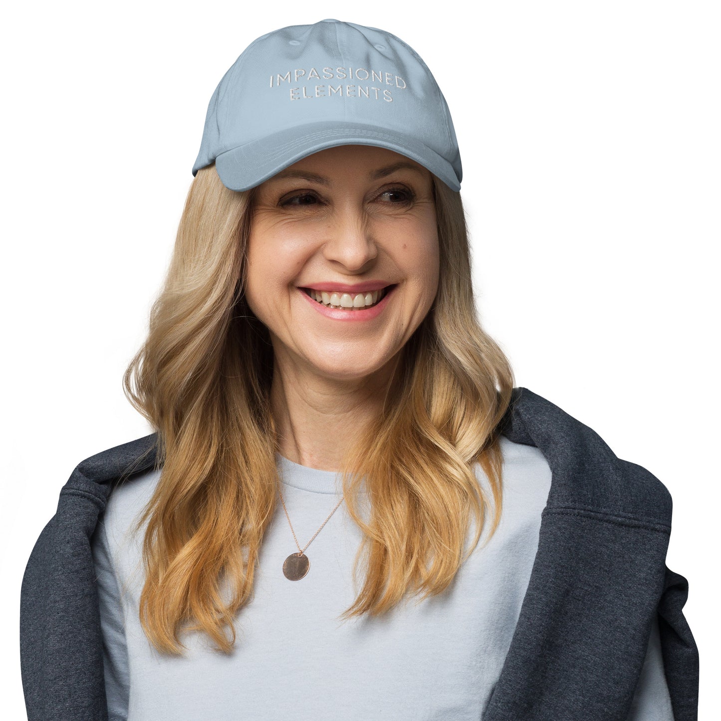Happy model smiling in a light blue Impassioned Elements embroidered cap