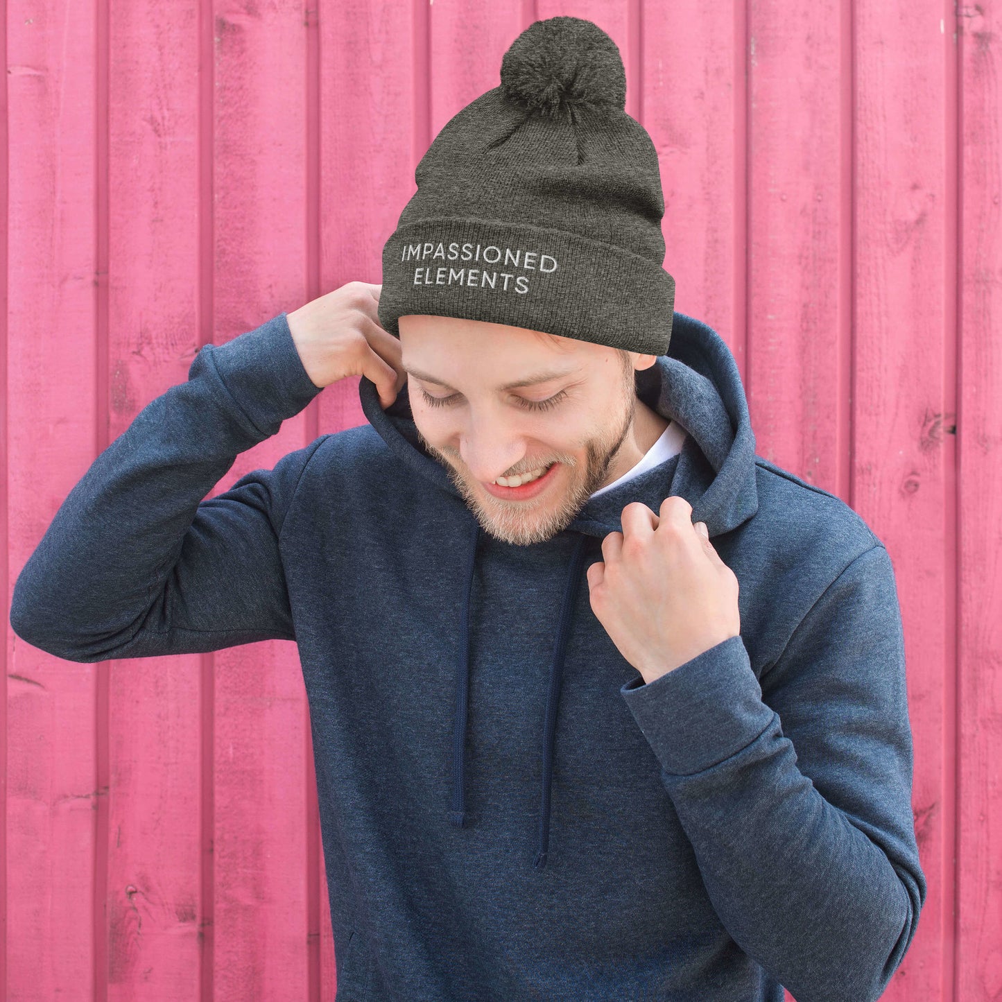 Smiling care-free man rocking our dark heather grey beanie with confidence